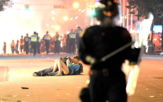 Moça se machuca em confusão com a polícia na final de hockey em Vancouver, Canadá, e namorado a acalma com um beijo, em 16 de junho (Foto: Getty Image)