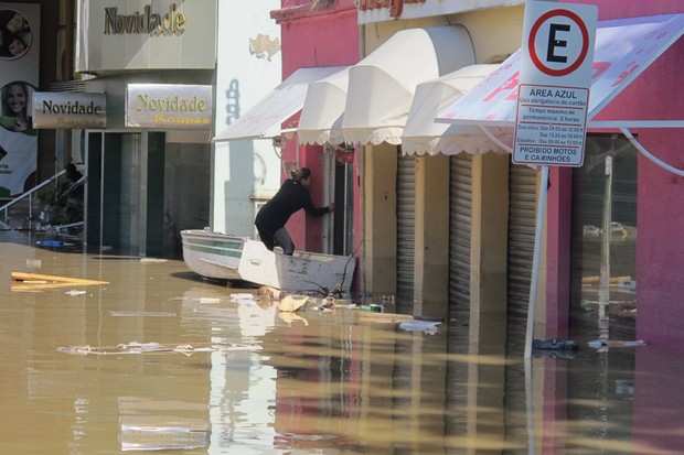 Mulher se arrisca de barco para tentar salvar objetos de uma das lojas inundadas no centro de Rio do Sul; a loja ficou alagada por cinco dias (Foto: Rosanne D'Agostiino/G1)