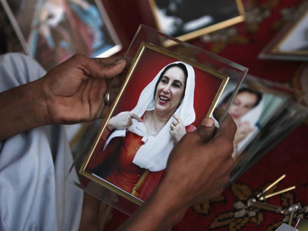  Homem segura foto de Benazir Bhutto em 31 de março no memorial improvisado que a celebra em Rawalpindi. (Foto: Reuters)