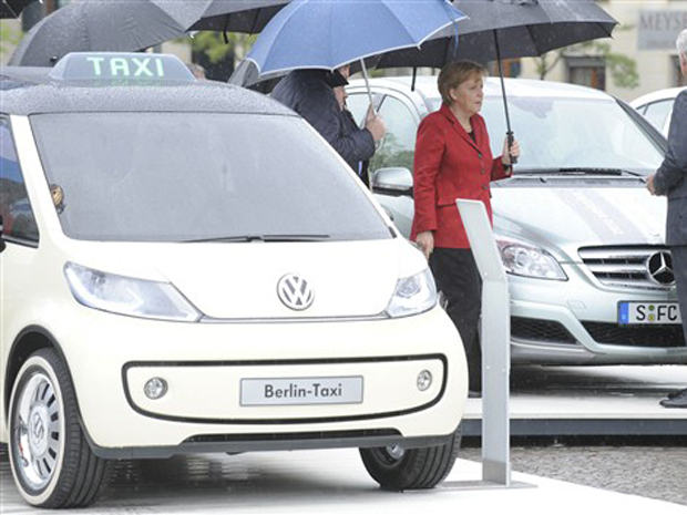 A chanceler alemã Angela Merkel ao lado do Táxi Berlin, carro-conceito elétrico voltado ao transporte coletivo.
