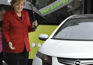 Chanceler alemã ao lado de um Opel Ampera.