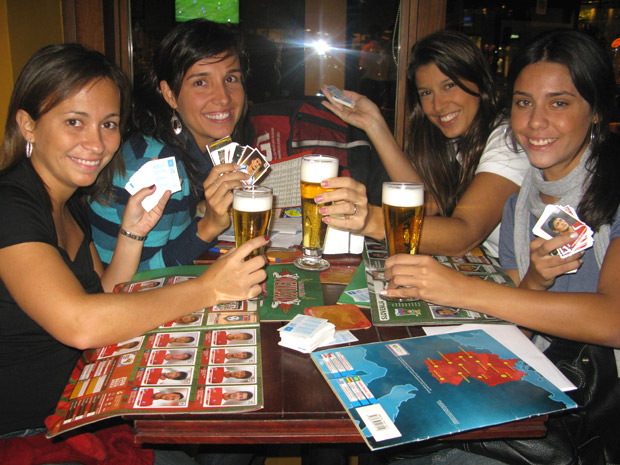 Joana, Marcela, Tatiana e Bárbara reunidas para trocar 
figurinhas, e beber um chope.