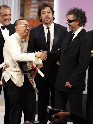 O diretor Apichatpong Weerasethakul, ao lado do ator Javier 
Bardem, recebe a Palma de Ouro de Tim Burton