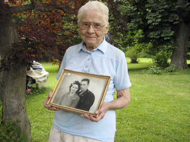 Jean Stevens mostra foto dos anos 1940 em que ela aparece ao lado de seu falecido marido, James, fora de sua casa em Wyalusing.