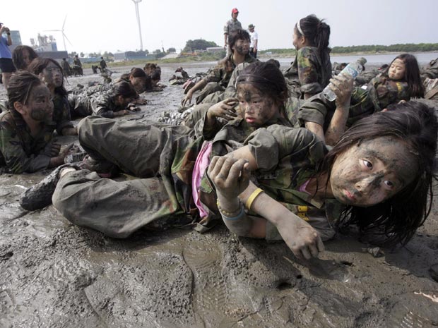 Estudantes sul-coreanas rastejam na lama durante acampamento 
militar infantil de verão na ilha Daebu, em Ansan, a sudoeste dce Seul.