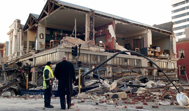Homens observam prédio parcialmente destruído em Christchurch, na Nova Zelândia, após terremoto nesta sexta-feira (3)