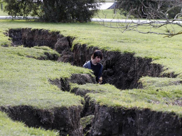 Homem caminha em rachadura provocada pelo terremoto de 4 de setembro em Kaiapoi, próximo à cidade de Christchurch, na Nova Zelândia, nesta quinta (9).