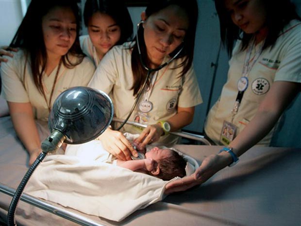 Médicos do aeroporto de Manila, nas Filipinas, examinam neste domingo (12) o bebê abandonado em um avião.