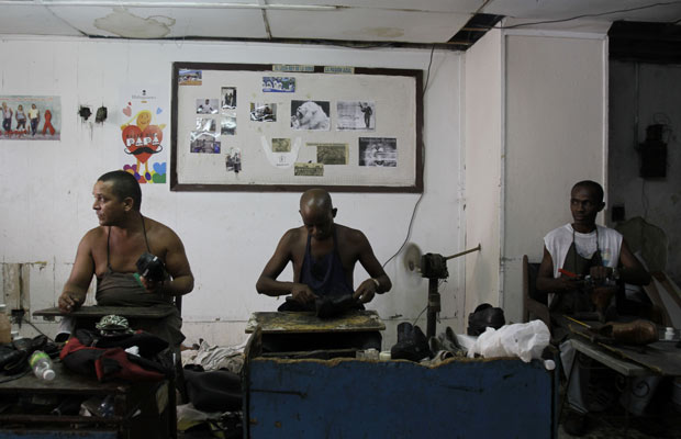 Trabalhadores consertam calçados na sapataria estatal 'La Habanera', em Havana, nesta segunda-feira (13).