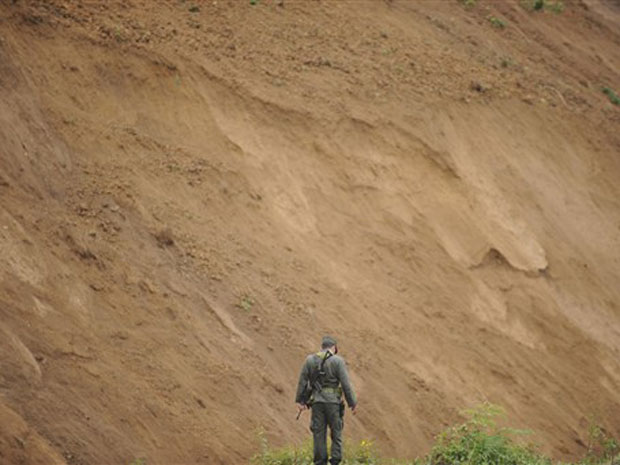 Policial patrulha o local do deslizamento nesta terça-feira (28) na Colômbia.