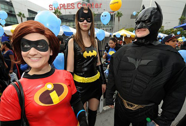 Pessoas fantasiadas de super-heróis posam para fotos neste sábado (2) em frente ao Staples Center, em Los Angeles.