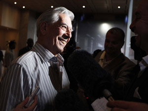 Mario Vargas Llosa sorri em entrevista a jornalista em Nova York depois de receber o anúncio do Nobel