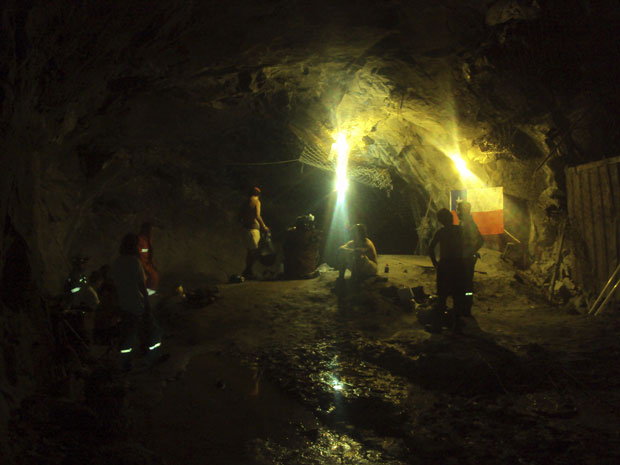 Os 33 mineiros chilenos reunidos na quarta-feira (13); na superfície, as operações de resgate iniciavam (Foto: Armada de Chile / Reuters)