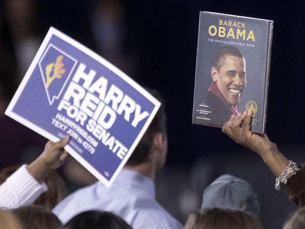 Eleitores seguram cartaz do candidato democrata ao Senado por Nevada, Harry Reid, e livro do presidente Obama durante comício em Las Vegas nesta segunda (2).