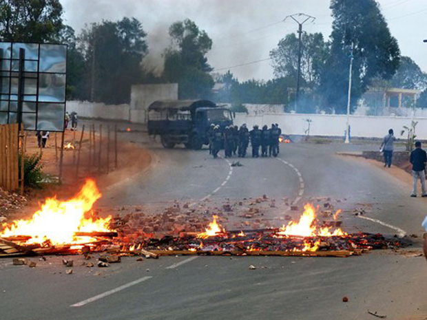 Soldados se aproximam de barricada feita por militares dissidentes em estrada próximo à capital de Madagascar, Antananarivo, nesta quarta-feira (17).