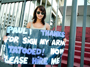 Em frente ao Morumbi, Ana Paula Hining carrega cartaz em que diz 'Paul! Obrigado por assinar meu braço. Eu tatuei! Agora, por favor, me contrate'