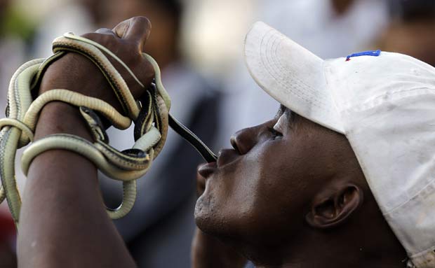 Homem engole cobras durante apresentação.