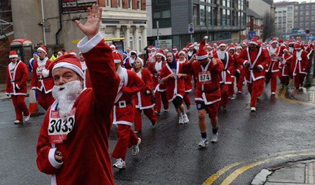 Milhares de corredores vestidos de Papai Noel participam de corrida em Liverpool, na Inglaterra, neste domingo (5)