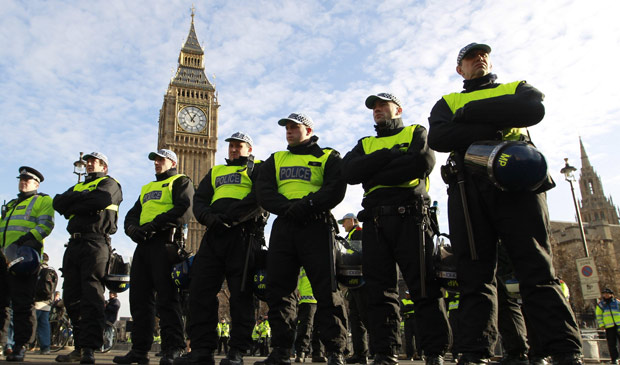 Policiais protegem a praça do Parlamento em Londres durante protesto de estudantes; a proposta de aumento de mensalidades tem dividido os partidos