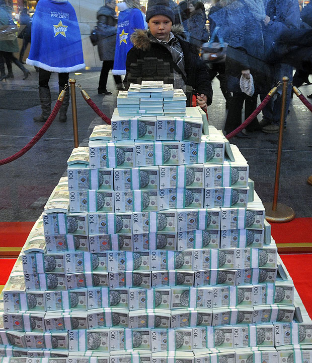 Menino observa o principal prêmio da loteria polonesa em dezembro que foi exposto em formato de pirâmide em um shopping na Polônia. Pesando 210 quilos, a pirâmide consiste em notas de dinheiro que equivalem a 23,378,863 Zlotys (moeda polonesa), ou US$ 7,792,954.
