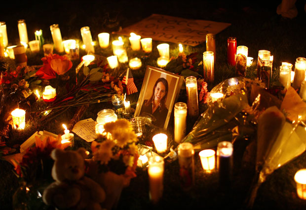 Foto de Gabrielle é cercada por velas durante uma vigília do lado de fora do University Medical Center, em Tucson, para onde a deputada foi levada.
