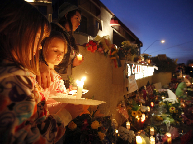 Garotas fazem vigília pela recuperação da deputada na noite deste domingo (9) em frente a hospital em Tucson, no estado americano do Arizona.