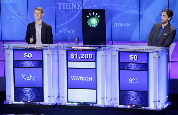 Os campeões Ken Jennings, à esquerda, e Brad Rutter, à direita, competem contra a máquina da IBM, no centro, em partida de teste.