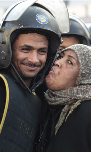 Manifestante beija policial durante protesto no Cairo