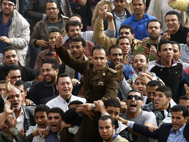 Oficial do exército se junta a manifestantes na praça Tahrir, durante protesto no Cairo