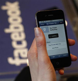 Usuário testa serviço de desconto em lojas do Facebook no lançamento do serviço na Europa. (Foto: Suzanne Plunkett/Reuters)
