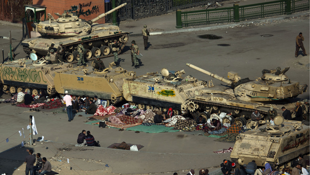 Manifestantes acampados próximo a tanques na Praça Tahrir, no Cairo, nesta quarta-feira (9) (Foto: AP)