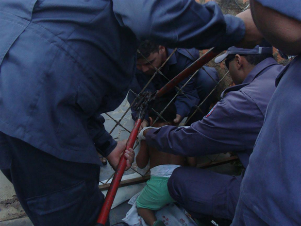 Bombeiros cortam grades para tentar retirar criança (Foto: Divulgação / Bombeiros)