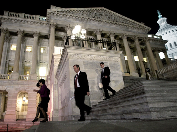 Congressistas descem as escadas da Câmara dos Representantes nesta sexta-feira (18) à noite. Eles avançaram a madrugada para votar o corte no orçamento. (Foto: AP)