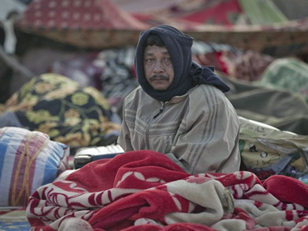 Líbio que saiu fugido de seu país acorda em Ras Jedir, no lado tunisiano da fronteira (Foto: Joel Saget/AFP)