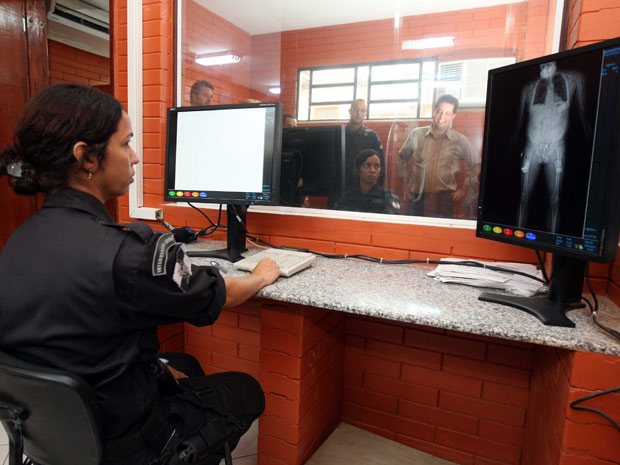 Inspetora monitora scanner na entrada do Complexo Penitenciário de Gericinó (Foto: Carlos Magno/Governo do Estado)