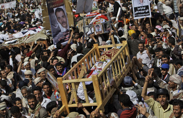 Manifestantes antigoverno carregam caixão de morto durante protestos de sexta-feira na capital Sanaa (Foto: Muhammed Muheisen/AP)