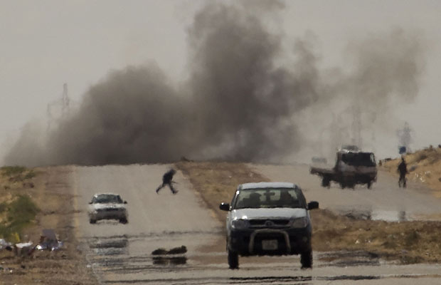 Opositores se protegem de bombardeio das forças de Kadhafi, na cidade de Ajdabiya (Foto: Anja Niedringhaus/AP)