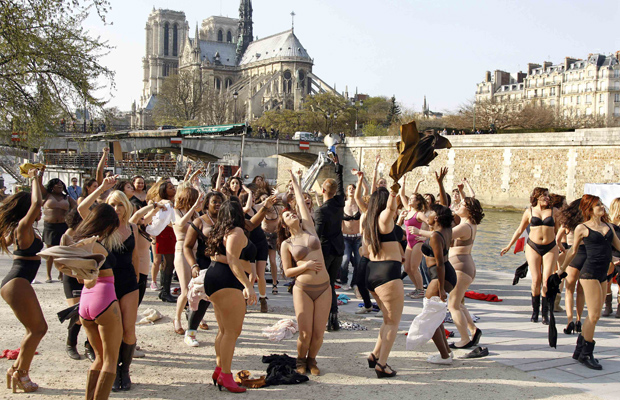 Mulheres dança só de roupa íntima durante o flash mob 'Belle toute nue' (belezas nuas), organizado nesta quarta-feira (23) por um canal de TV em frente à Catedral de Notre Dame, em Paris. (Foto: Reuters)