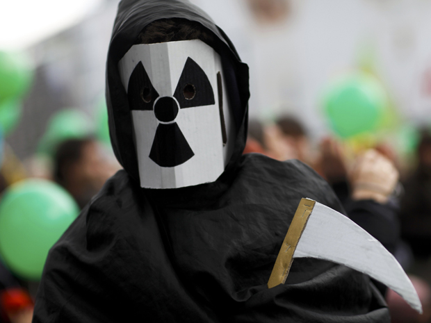 Um manifestante ant-nuclear usa máscara durante protesto em Berli . Milhares de pessoas são esperadas neste protesto em toda a Alemanha (26/3) (Foto: Reuters)