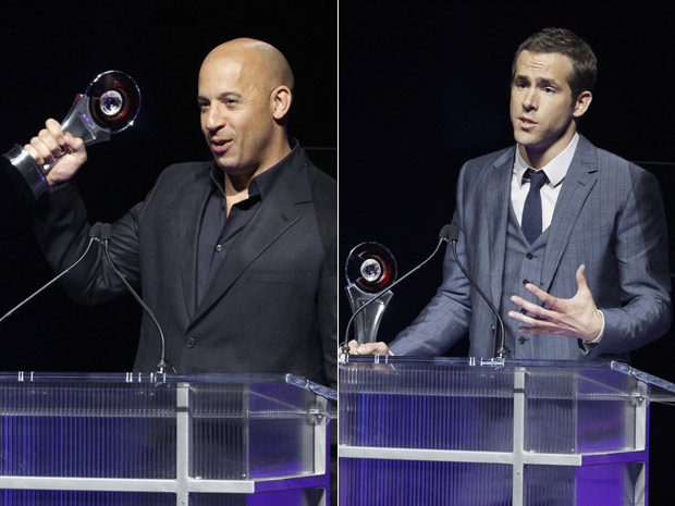 O ator Vin Diesel (à esquerda) foi premiado como estrela de ação do ano no Big Screen Achievement Award da CinemaCon. À direita, Ryan Reynolds recebe o prêmio de astro masculino em Las Vegas. (Foto: AP)
