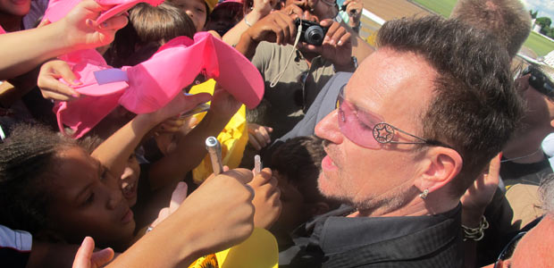O cantor Bono, do U2, rodeado por fãs na saída do Palácio da Alvorada, após reunião com a presidente Dilma Rousseff (Foto: Débora Santos/G1)
