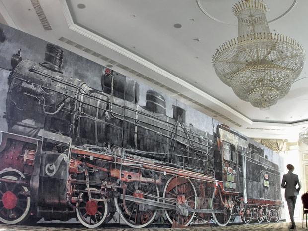 Pintura em tamanho real de uma locomotiva a vapor de 1889 é exibida em Bucareste, Romênia, nesta sexta-feira (8). A obra, de 20 metros de extensão e 4,5 de altura, deve ser leiloada na próxima semana por um preço de até US$ 86 mil, Os organizadores dizem que a obra pode ser incluída no livro dos recordes como a maior  obra de arte já leiloada. (Foto: AP)
