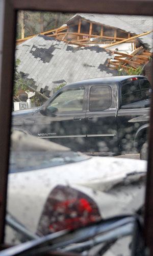 Vidro mostra imagem de destruição após o tornado da região de Clinton, no Mississipi (Foto: Rogelio V. Solis/AP)