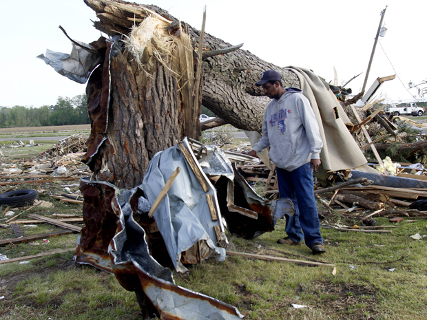 Morador entre destroços nesta segunda-feira (18) em Colerain, no estado americano da Carolina do Norte (Foto: AP)