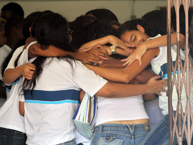 Estudantes se abraçam no retorno à Escola Municipal Tasso da Silveira, nesta segunda-feira (18) (Foto: Fabio Motta/AE)