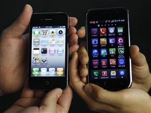 Funcionários de loja sul-coreana comparam iPhone 4 (à esquerda) com Galaxy S, da Samsung (Foto: Truth Leem/Reuters)