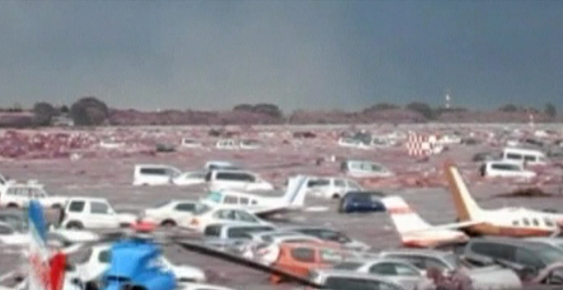 Imagem divulgada pela Guarda Costeira mostra o tsunami varrendo carros e aeronaves (Foto: BBC)