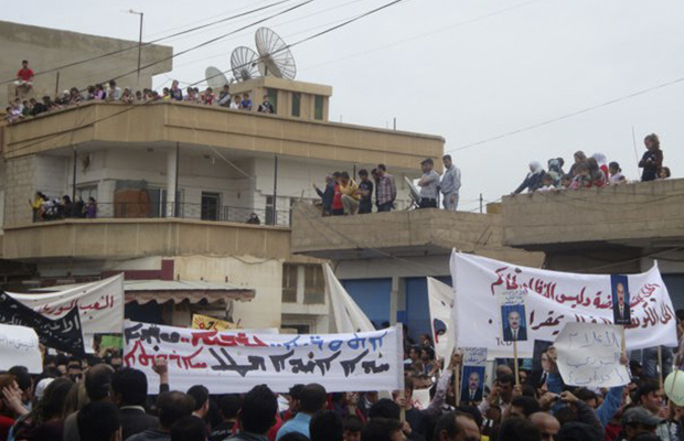 Manifestantes protestam contra o governo da Síria nesta sexta-feira (29) em Qamishli (Foto: AP)