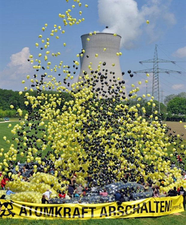 Manifestantes com faixa com dizeres 'Fechem a usina nuclear' soltam balões em frente à usina próxima à cidade de Gundremmingen (Foto: AFP)