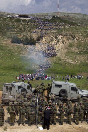 Soldados israelenses fazem a guarda na fronteira com a Síria enquanto multidão de manifestantes corre em direção à borda (Foto: Jack Guez/AFP)